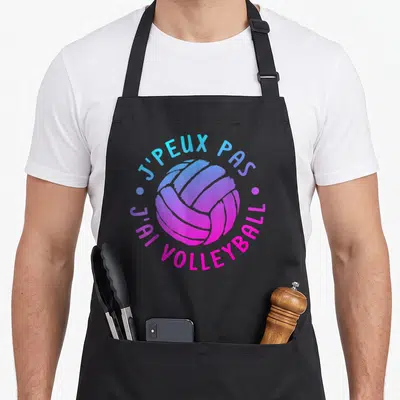 Tablier de cuisine noir avec illustration d'une balle de volleyball aux couleurs dégradées et texte circulant autour.