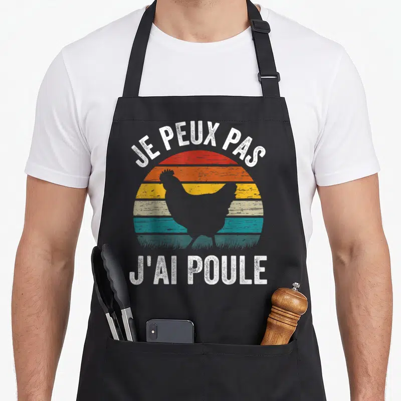 Tablier de cuisine noir avec silhouette de poulet sur fond de soleil vintage et texte blanc Je Peux Pas J'ai Poule