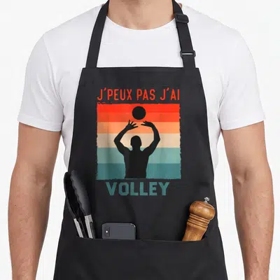 Tablier de cuisine noir avec silhouette joueur volley et texte j'peux pas j'ai volley maillot joueurs sur fond rayé vintage.