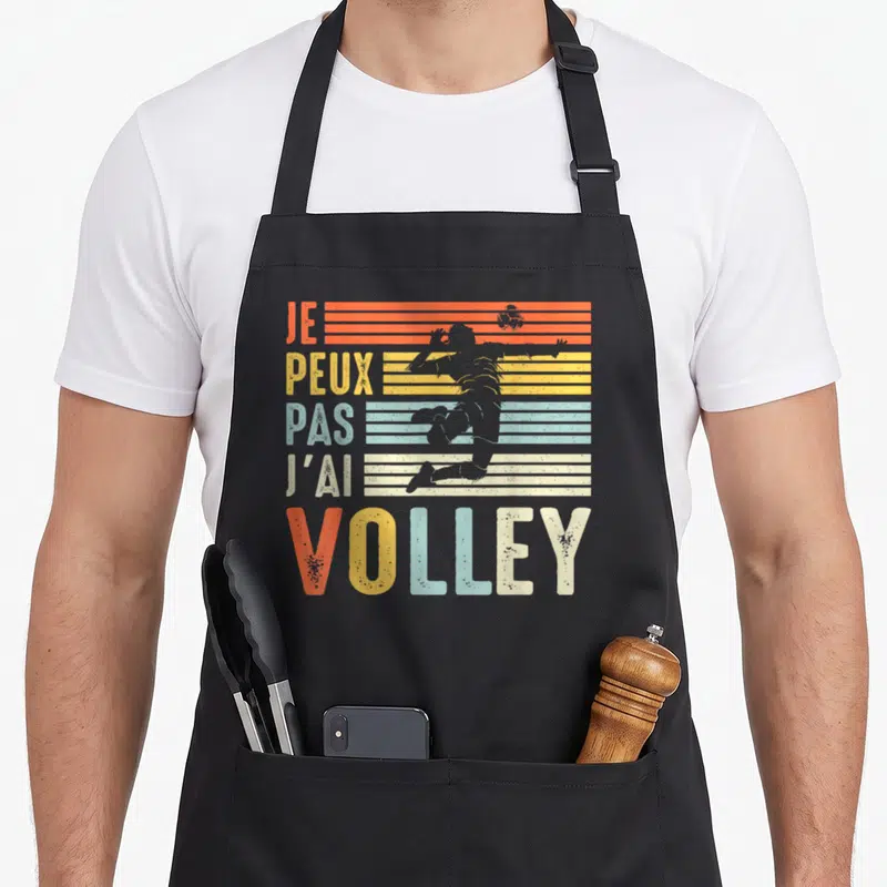 Tablier de cuisine noir avec motif vintage Je Peux Pas J'ai Volley et silhouette de joueur en saut.