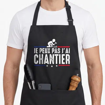 Tablier de cuisine noir avec inscription Je peux pas j'ai chantier et silhouette d'ouvrier en train de frapper avec un marteau.