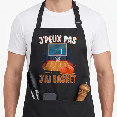 Tablier de cuisine noir avec illustration d'un panier de basket, deux ballons oranges et le texte J'PEUX PAS J'AI BASKET