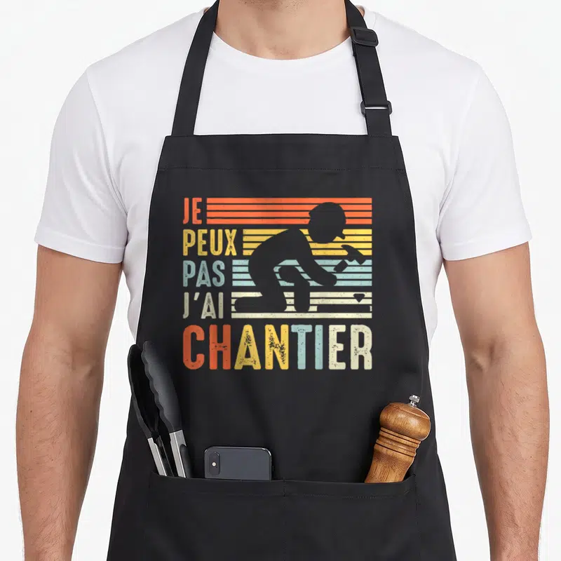 Tablier de cuisine noir avec silhouette deouvrier et texte Je Peux Pas JAi Chantier en couleurs vintage.