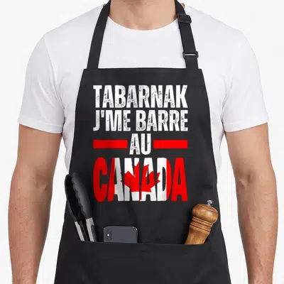 Tablier de cuisine noir avec inscription blanche et rouge Tabarnak je me barre au Canada sur fond gris uni.
