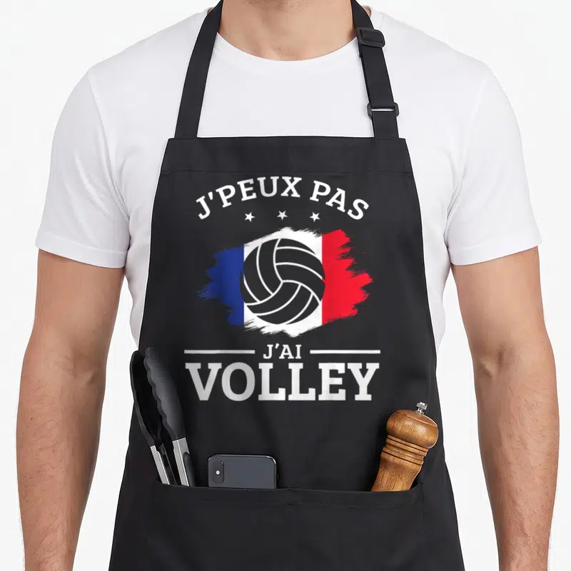 Tablier de cuisine noir avec motif tricolore, balle de volley et texte J'peux pas j'ai Volley en blanc.
