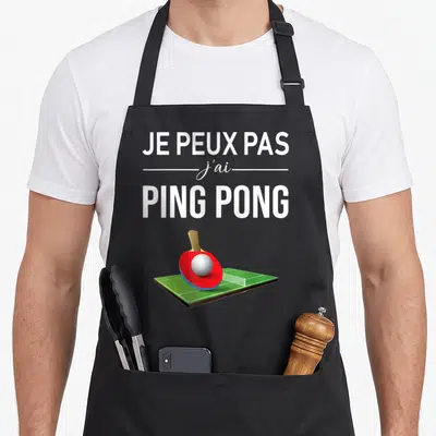 Tablier de cuisine noir avec inscription Je peux pas j'ai Ping Pong et illustration d'une table de tennis de table avec une raie rouge.