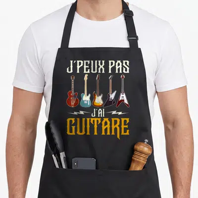 Tablier de cuisine noir avec l'inscription J'peux pas j'ai guitare et cinq illustrations d'instruments variés en couleurs vives.