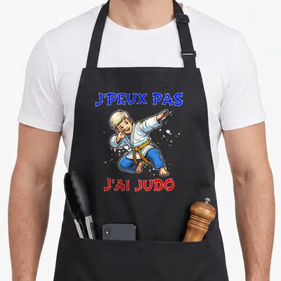 Tablier de cuisine noir avec illustration d'un jeune garçon en judo et texte j'peux pas j'ai judo.