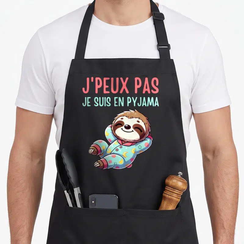Tablier de cuisine noir avec un paresseux en pyjama et le texte J'peux pas je suis en pyjama
