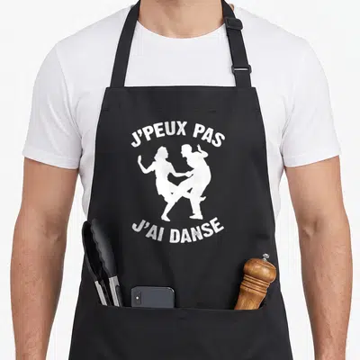 Tablier de cuisine noir avec texte blanc et silhouettes d'un couple en train de danser ensemble.