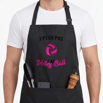 Tablier de cuisine noir avec une balle de volley-ball rose et le texte j'peux pas j'ai volley-ball imprimé en noir et rose.
