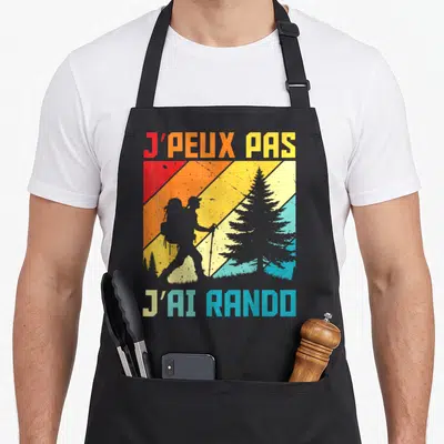 Tablier de cuisine noir avec silhouette de randonneur et texte j'peux pas j'ai rando sur fond rayé coloré.