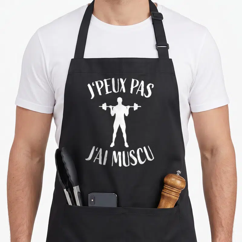Tablier de cuisine noir avec silhouette blanche levant une barre et texte j'peux pas j'ai muscu