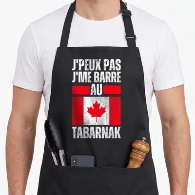 Tablier de cuisine noir avec inscription blanche jpeux pas jme barre au Canada tabarnak sur fond de drapeau rouge et blanc vieilli.