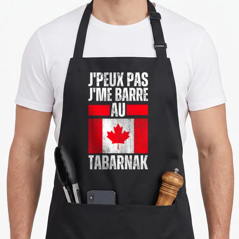 Tablier de cuisine noir avec inscription blanche jpeux pas jme barre au Canada tabarnak sur fond de drapeau rouge et blanc vieilli.