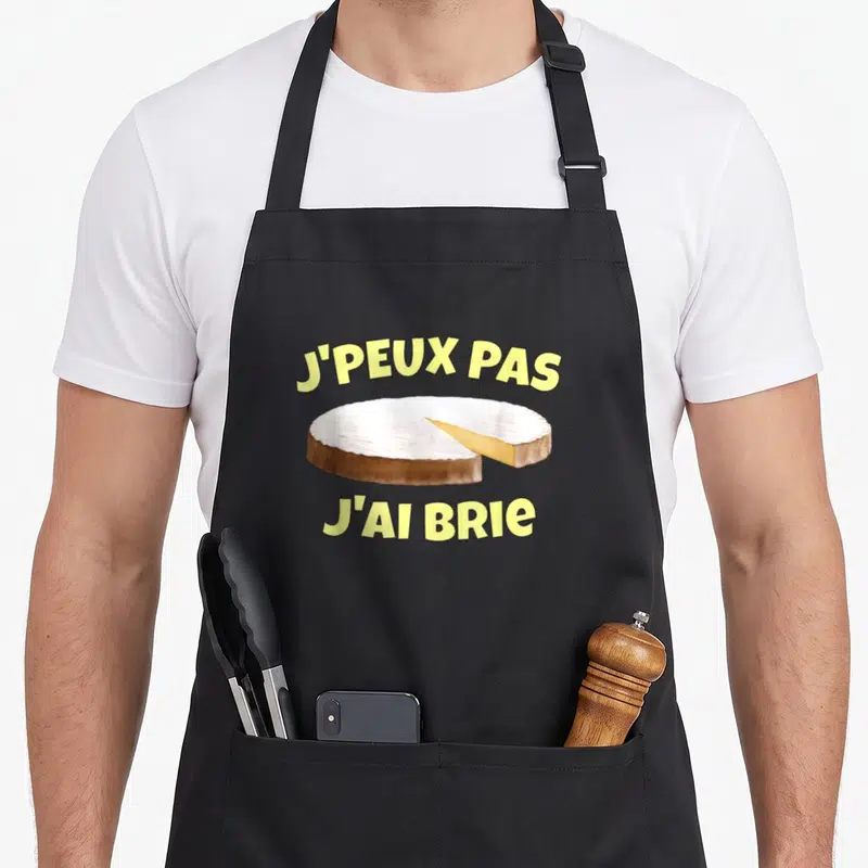 Tablier de cuisine noir avec illustration de Brie et texte J'peux pas j'ai Brie en jaune