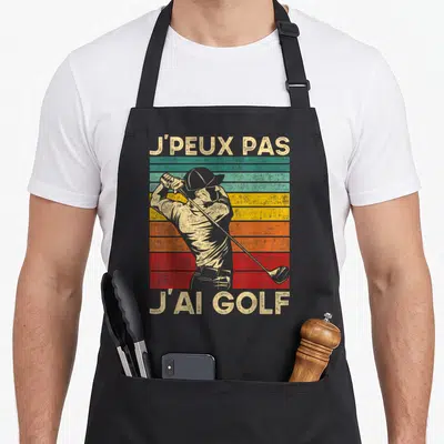 Tablier de cuisine noir avec illustration vintage d'un golfeur et le texte j'peux pas j'ai golf en lettres capitales.