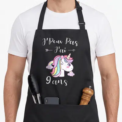 Tablier de cuisine noir avec une licorne aux cheveux arc-en-ciel et l'inscription 9 ans en blanc.