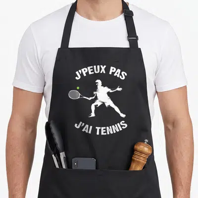 Tablier de cuisine noir avec silhouette blanche de joueur de tennis et texte j'peux pas j'ai tennis