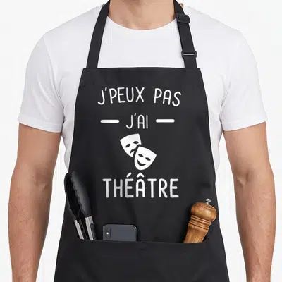 Tablier de cuisine noir avec inscription blanche J'peux pas j'ai théâtre et deux masques de théâtre superposés.