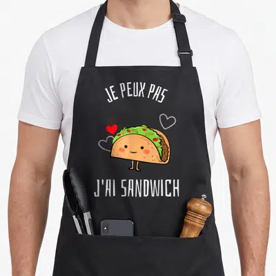 Tablier de cuisine noir avec un taco souriant, des cœurs et le texte je peux pas j'ai sandwich.