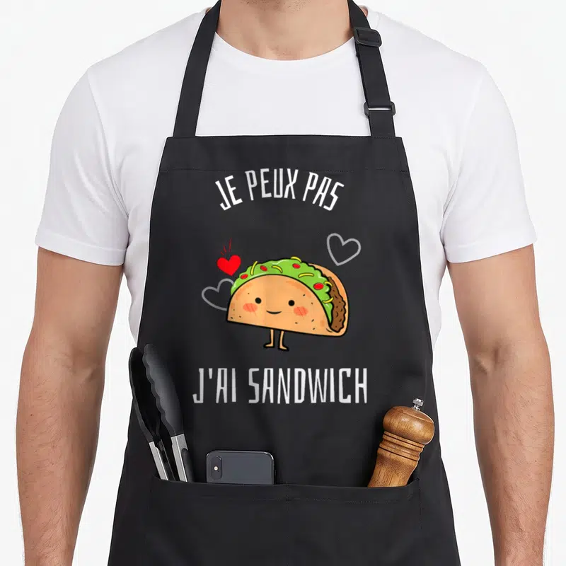 Tablier de cuisine noir avec un taco souriant, des cœurs et le texte je peux pas j'ai sandwich.