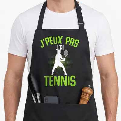 Tablier de cuisine noir avec silhouette blanche de joueur de tennis et texte vert j'peux pas j'ai tennis