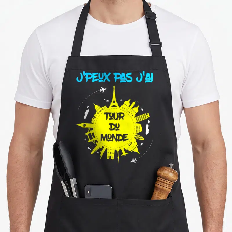 Tablier de cuisine noir avec inscription j'peux pas j'ai tour du monde et silhouettes de monuments mondiaux jaunes.