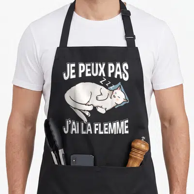 Tablier de cuisine noir avec un chat blanc dormant et le texte je peux pas j'ai la flemme imprimé en blanc.