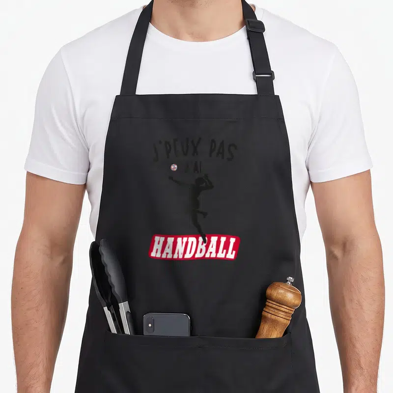 Tablier de cuisine noir avec silhouette de joueuse de handball et texte j'peux pas j'ai handball femme en noir et rouge.