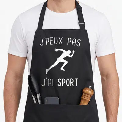 Tablier de cuisine noir avec une silhouette blanche de sprinter et le texte j'peux pas j'ai sport imprimé en haut et en bas.