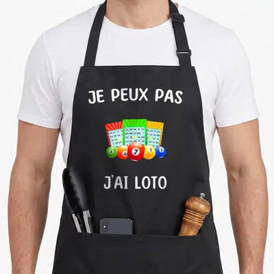 Tablier de cuisine noir avec trois tickets de loto colorés, cinq boules numérotées et le texte je peux pas j'ai loto en blanc.