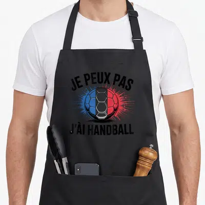 Tablier de cuisine noir avec une balle de handball aux couleurs du drapeau français et le texte je peux pas j'ai handball.