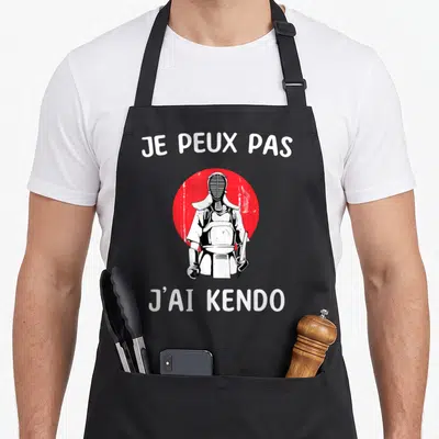 Tablier de cuisine noir avec un pratiquant de kendo et le texte je peux pas j'ai kendo en blanc.