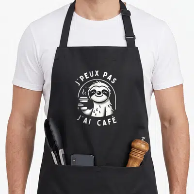 Tablier de cuisine noir avec un loup garou blanc tenant une tasse de café fumante.