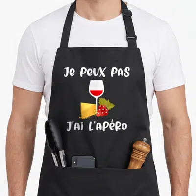 Tablier de cuisine noir avec un verre de vin rouge, du fromage et des raisons imprimés au centre.