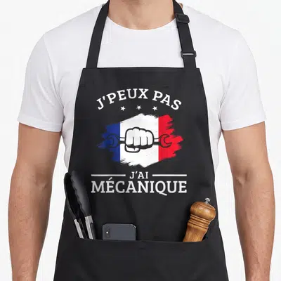 Tablier de cuisine noir avec illustration poing serré tenant une clé sur fond tricolore français et texte blanc.
