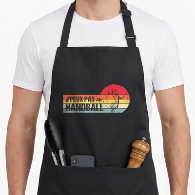 Tablier de cuisine noir avec motif vintage coloré et silhouette de joueur de handball en action.