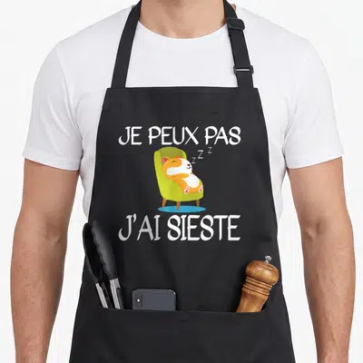 Tablier de cuisine noir avec hamster doré dormant dans un fauteuil vert et texte blanc Je peux pas j'ai sieste