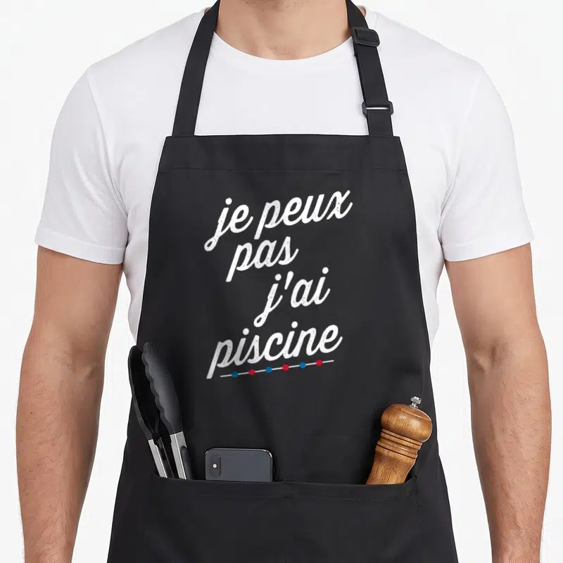 Tablier de cuisine noir avec texte blanc je peux pas j'ai piscine et lignes de nage colorées en bas.
