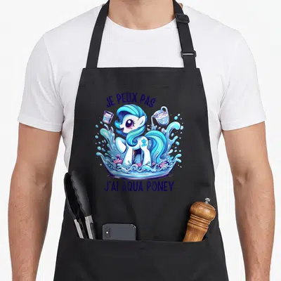 Tablier de cuisine noir avec illustration colorée d'Aqua Poney dans une flaque d'eau et un verre.