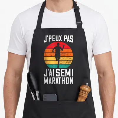 Tablier de cuisine noir avec silhouette de coureur et texte J'peux pas j'ai semi marathon en style vintage.