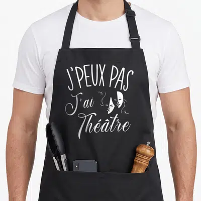 Tablier de cuisine noir avec inscription blanche J'peux pas j'ai théâtre et deux masques de théâtre stylisés.
