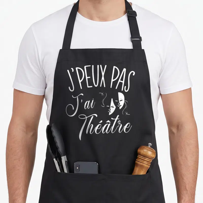 Tablier de cuisine noir avec inscription blanche J'peux pas j'ai théâtre et deux masques de théâtre stylisés.