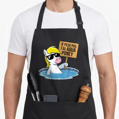 Tablier de cuisine noir avec un poney blanc aux cheveux blonds tenant une pancarte dans une piscine bleue.