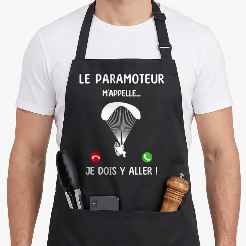 Tablier de cuisine noir avec illustration d'un paramoteur blanc et icônes de téléphone rouge et vert.