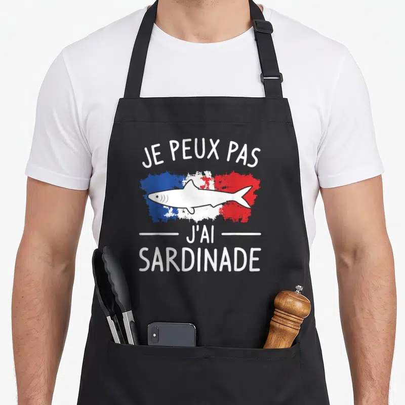 Tablier de cuisine noir avec illustration d'un poisson sur fond tricolore et texte blanc Je Peux Pas J'ai Sardinade Sardines