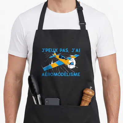 Tablier de cuisine noir avec avion orange et bleu et texte j'peux pas j'ai aéromodélisme imprimé en bleu.