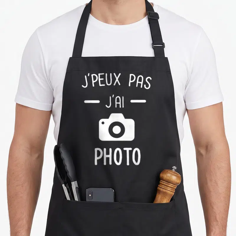 Tablier de cuisine noir avec inscription blanche J'peux pas j'ai photo et icône appareil photo stylisée au centre