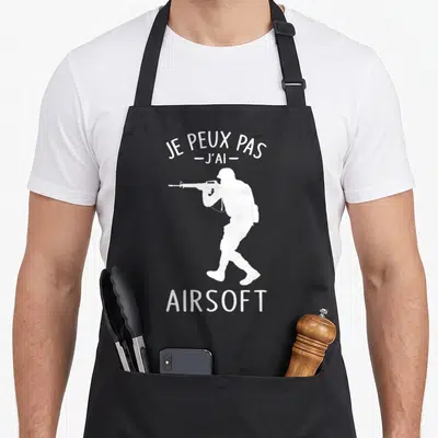 Tablier de cuisine noir avec silhouette blanche soldat pointant un airsofteur et texte Je Peux Pas J'ai Airsoft